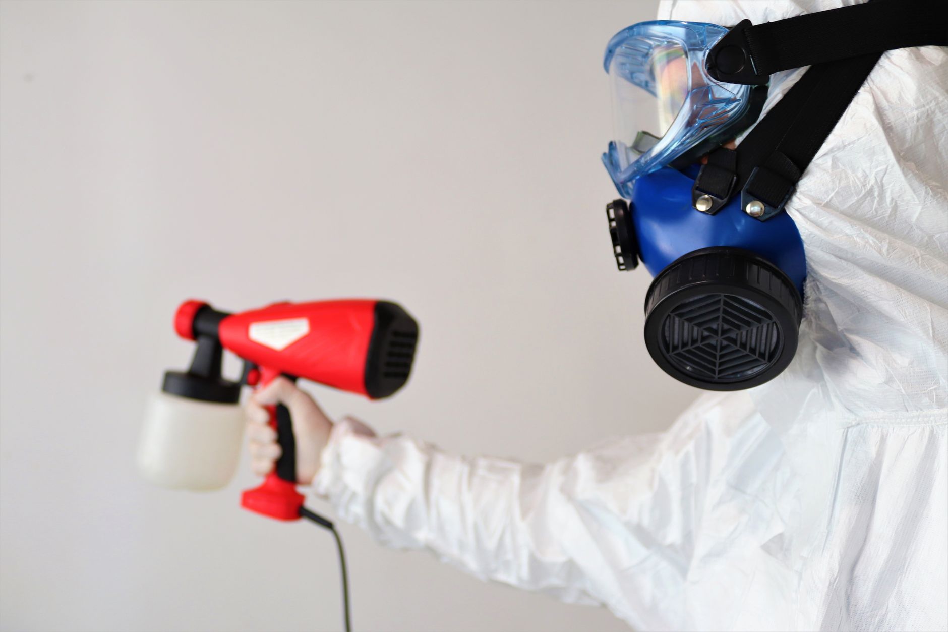 A technician in full PPE setting up containment barriers in a Gustine home's attic, preparing for mold removal with specialized equipment.